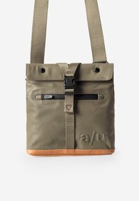 Olijfgroene tas met een gladde afwerking, voorzien van een voorvak met rits, verstelbare band en een bruine leren bodem. Gemarkeerd met "a/u."