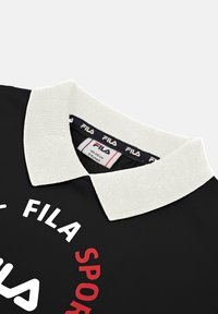 Polo nero con colletto a coste bianco. Presenta un marchio in testo rosso e bianco sul davanti e un'etichetta per la cura all'interno del colletto.