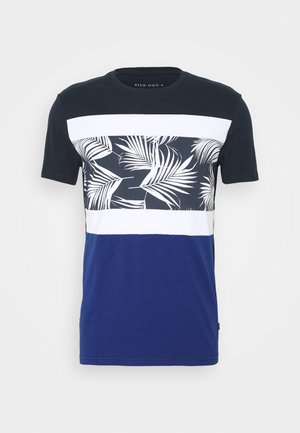 T-shirt à manches courtes avec épaules noires, bande à motif de feuilles de palmier blanches et noires, bande blanche et partie inférieure bleue.