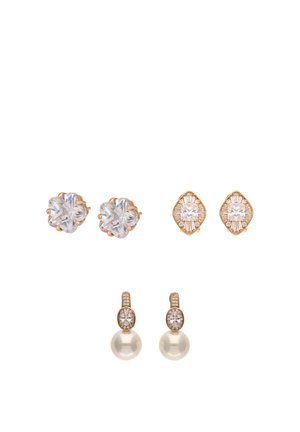 Drie paar oorstekers: heldere kristallen bloem, goudkleurige geometrische met heldere stenen, en gouden druppel met kleine kristallen en parel.