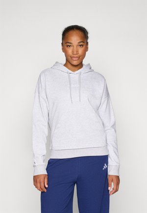 Grijze katoenen hoodie met een kangoeroezak, capuchon met trekkoord en geribbelde manchetten, gedragen met blauwe joggingbroeken met een wit logo.