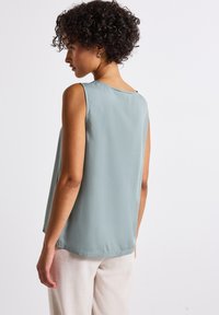 Sleeveless, light green top made of smooth fabric. Features a round neckline, a relaxed fit, and a slightly longer back hem.