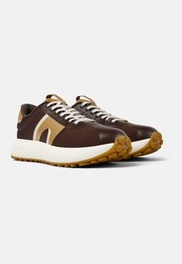 Sneaker in rete marroni con accenti beige in contrasto, lacci bianchi, suola intermedia spessa bianca e suola in gomma testurizzata.