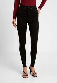 Zwarte high-waisted skinny jeans van denim, met een sluiting met een knoop en rits aan de voorkant, zijzakken en een taps toelopend ontwerp.