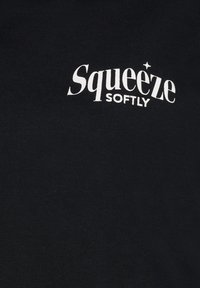 Schwarzes T-Shirt mit weißem Drucktext, der "Squeeze Softly" lautet. Weiches Baumwollmaterial mit klassischem Rundhalsausschnitt.