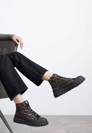 Sneaker alte realizzate in tessuto con stampa animalier, con suole in gomma nera, dotate di lacci e cerniere laterali per una vestibilità facile.
