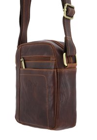 Braune Leder-Umhängetasche mit strukturierter Oberfläche, ausgestattet mit einer Reißverschlusstasche auf der Vorderseite und einem verstellbaren Riemen mit Metallbeschlägen.