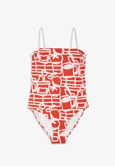 Maillot de bain une pièce rouge avec des motifs blancs abstraits évoquant des tasses et des fruits, doté de fines bretelles blanches.
