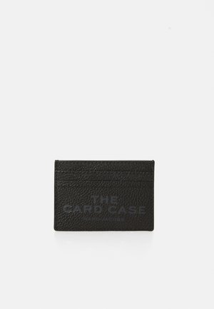 Musta tekstuuriga nahast kaarditasku mitme slotiga, mille esiküljel on pealtprintitud "THE CARD CASE" ja "MARC JACOBS".