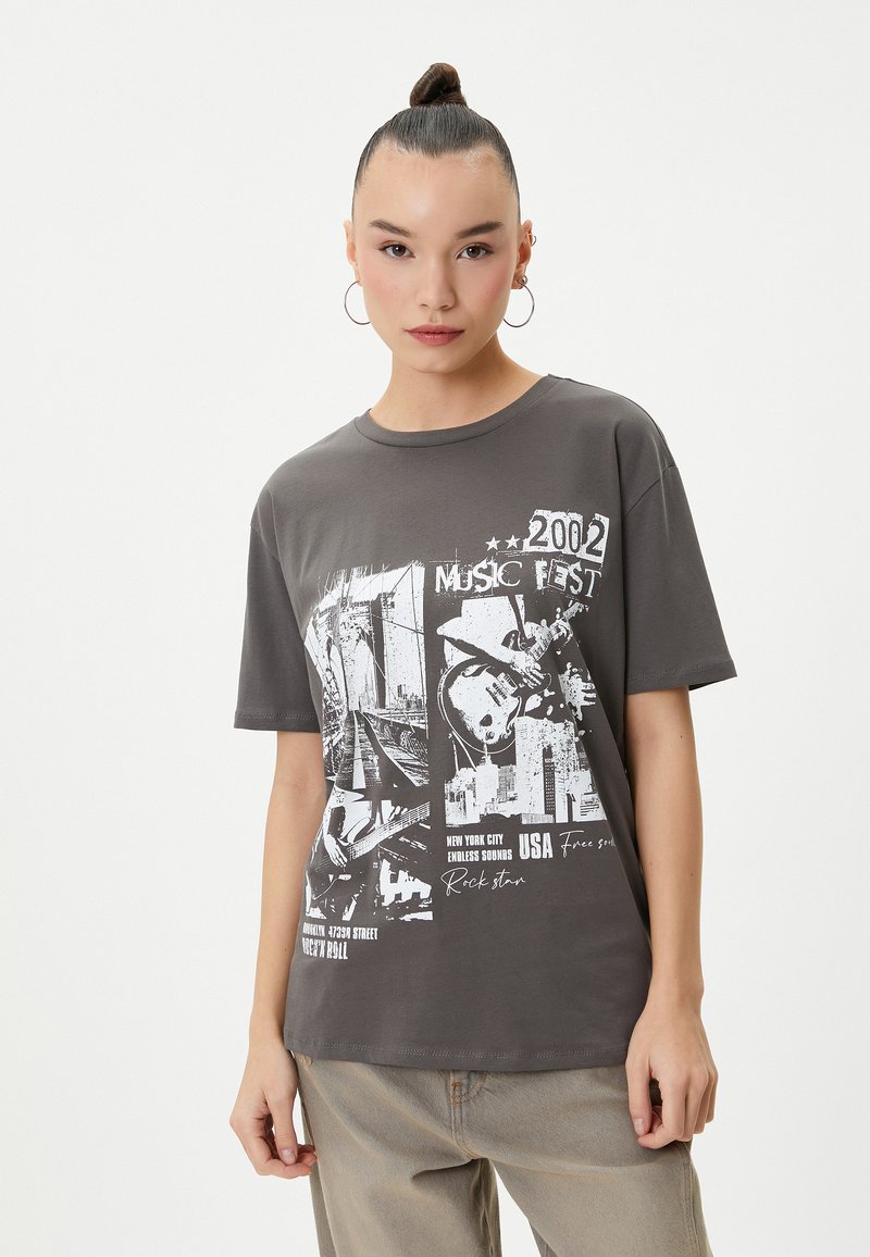 Grijze katoenen T-shirt met een grafische print van muziekfestival-elementen en tekst uit 2002. Korte mouwen, relaxte pasvorm, ronde halslijn.
