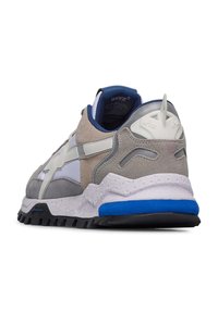 Grå och vit sneakers med en texturerad mockaövre, blå accenter, en tjock gummisula och en vadderad krage för komfort.