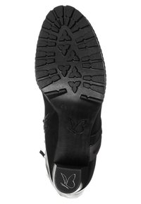 Suela de zapatos negra con un patrón de agarre texturizado y un logo de mariposa. Presenta una parte superior de cuero suave y un talón moldeado para soporte.