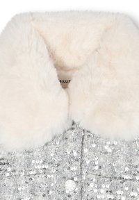 Veste en sequins argentés avec un doux col en fausse fourrure blanche, fermeture à boutons et tissu texturé. Détail avec une surface scintillante.