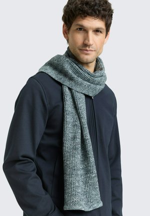 Écharpe tricotée texturée en gris foncé avec des accents clairs, dotée d'un tissu doux et épais qui tombe librement autour du cou.