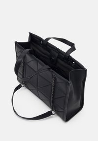 Černá prošívaná kabelka s koženými a řetízkovými ušními, otevřený vrch s kovovým zapínáním a prostornými vnitřními přihrádkami.