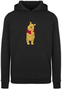 Zwarte hoodie met een voorzak en een afbeelding van een gele beer in een rood shirt, weergegeven in een casual, ontspannen houding.