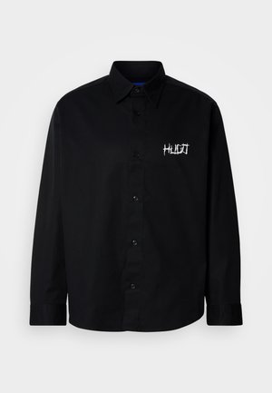 Zwart katoenen overhemd met knoopsluiting, voorzien van een kraag en lange mouwen. Heeft een wit geborduurd logo op de linkerborst.