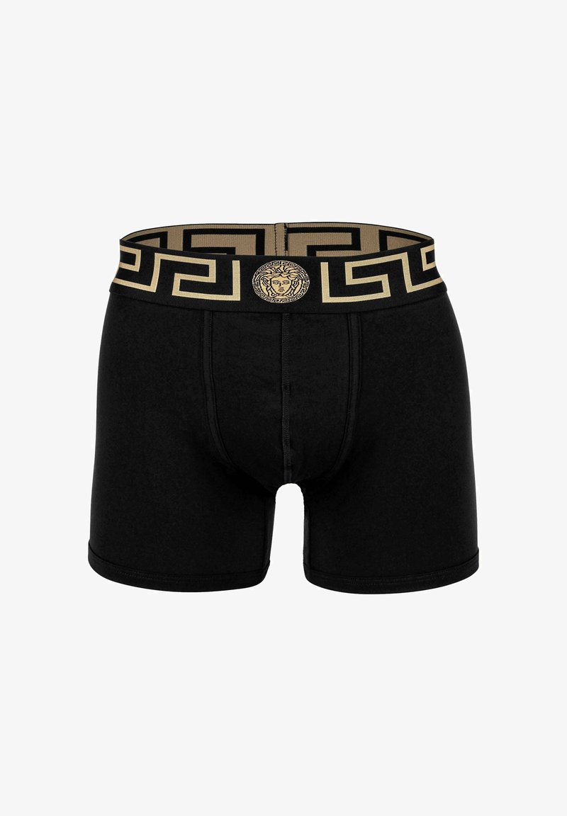 Black boxer briefs made of a soft fabric. Features a gold patterned waistband with a iconic logo at the center. Smooth texture and fitted design.