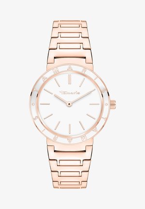 Montre en métal rose doré avec un cadran blanc rond, des index d'heure fins et un bracelet à maillons. Le nom de la marque est inscrit autour de la lunette.