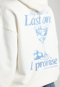 White hooded sweatshirt featuring a blue graphic of a cocktail glass and text: "Last one I promise" with "Big Night Out" above.