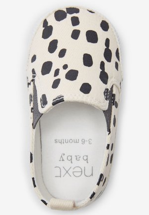 Chaussure pour bébé en toile crème avec des taches léopard noires. Modèle à enfiler avec des panneaux latéraux élastiques. Étiquette à l'intérieur indiquant la taille : 3-6 mois.