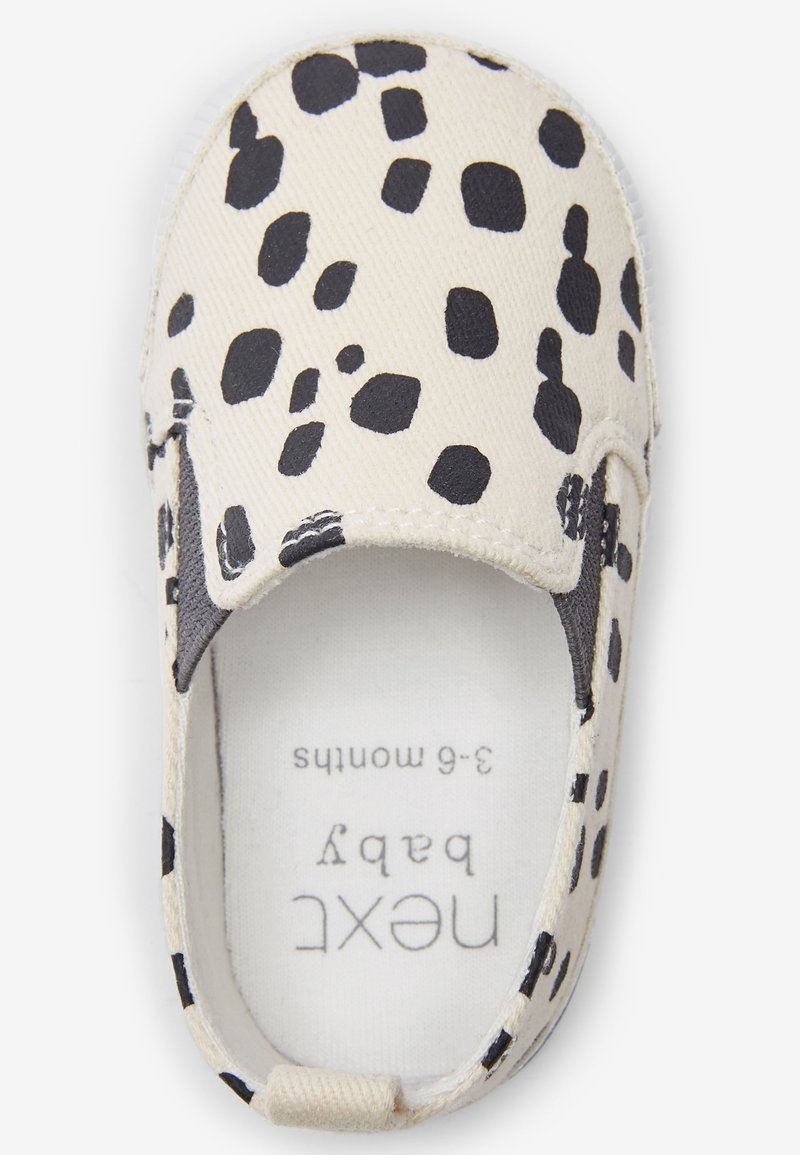 Chaussure pour bébé en toile crème avec des taches léopard noires. Modèle à enfiler avec des panneaux latéraux élastiques. Étiquette à l'intérieur indiquant la taille : 3-6 mois.