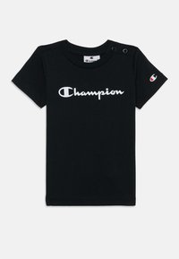 Schwarzes Baumwoll-T-Shirt mit kurzen Ärmeln, mit weißem "Champion"-Logo. Zwei Druckknöpfe an der linken Schulter. Kleines Logo am Ärmel.