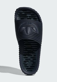 Navy blue slide sandal made of rubber, featuring textured ridges and an embossed logo on the strap. Slotted sole for ventilation.