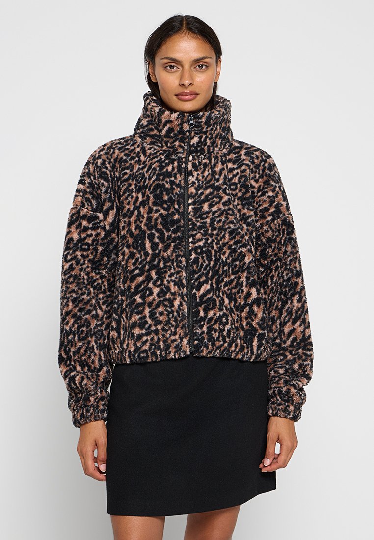 Fleece-Jacke im Leopardenmuster mit hohem Kragen und Reißverschluss. Weiche Textur, schwarz-beige Muster. Taillierter Schnitt mit elastischen Bündchen.
