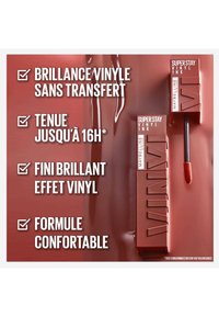 Rouge à lèvres liquide marron dans un contenant rectangulaire avec une finition brillante. Comprend un applicateur en forme d'oreille de lièvre et du texte mettant en avant ses caractéristiques.