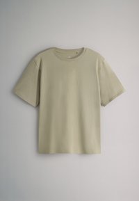 T-shirt à manches courtes en coton beige clair. Présente un col rond, une coupe décontractée et une texture lisse. Design minimaliste sans motifs.