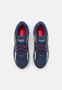 Zapatillas deportivas de color azul marino con tejido de malla, detalles en rojo y adornos blancos. Presentan cordones y una plantilla acolchada para mayor comodidad.