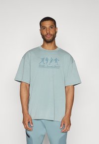 Under Armour ATHLETES  - Apdrukāts T-krekls - serpentine/jasper blue