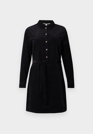 Zwarte corduroy jurk met een knoopsluiting aan de voorkant, lange mouwen en een strikband in de taille. Heeft een klassieke kraag en zijzakken.