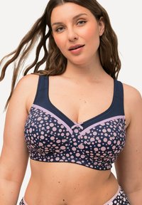 Marineblauwe beha met roze stippen, brede bandjes, zachte textuur, een kanten rand en een klein strikje in het midden vooraan.