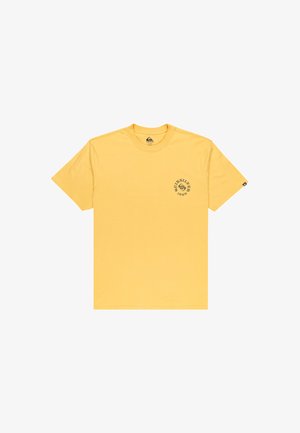 Gelbes Quiksilver T-Shirt mit kurzen Ärmeln, kleinem schwarzem Logo und dem Text "1969" auf der linken Brust sowie einem schwarzen Etikett am linken Ärmel.