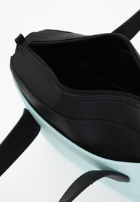 Zaino nero e azzurro chiaro con apertura con zip. Realizzato in materiale sintetico liscio, con spallacci neri e un interno spazioso.