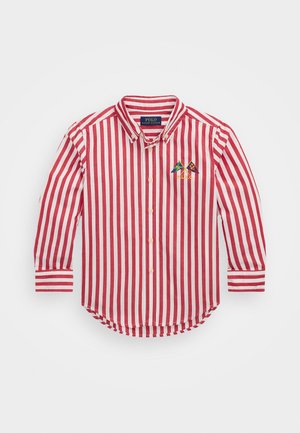 Camisa de botones a rayas rojas y blancas con cuello, mangas largas y un diseño bordado de una montaña. Tejido de algodón suave con un dobladillo curvado.