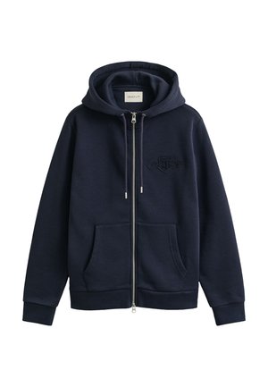 Tmavomodrá mikina na zips s kapucňou so sťahovacou šnúrkou, prednými vreckami, rebrovanými manžetami a malým vyšívaným logom na hrudi.