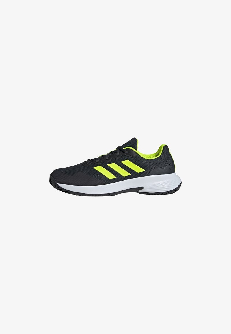 Pantofii sport negri au un superior din plasă, trei dungi proeminente de culoare galben neon, un intermediar alb și o talpă exterioară din cauciuc texturat.