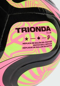 Černý fotbalový míč s jasně růžovými a zelenými geometrickými vzory. Obsahuje text "TRIONDA CLUB" a "MATCH BALL REPLICA" tučným písmem.