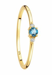 Anello d'oro con una pietra blu rotonda centrale affiancata da due piccole pietre trasparenti, con una finitura liscia e lucida e una fascia sottile.