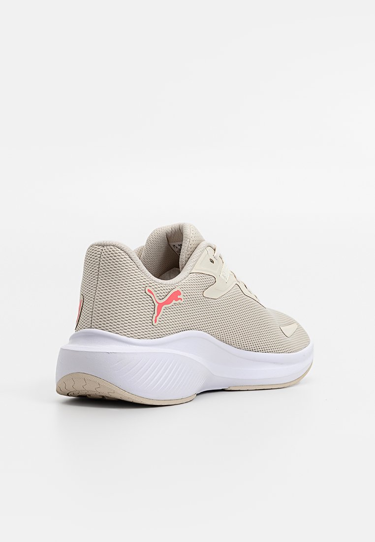 Baskets Puma beiges avec logo rose, tige en mesh, semelle blanche épaisse et semelle beige, vues de l'arrière et de côté sur un fond blanc.