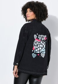 Zwarte denimjack met een grafische print op de achterkant met kleurrijke harten en de tekst "Beautiful Life." Klassieke kraag en knoopsluiting.