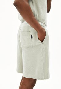 Groene katoenen badstof shorts met een zijzak en een ontspannen pasvorm, voorzien van een zachte textuur en een elastische tailleband.