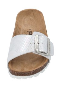 Sandale blanche à semelle glissante avec une sangle texturée irisée, boucle métallique ajustable et semelle en liège. Semelle blanche solide avec une traction.