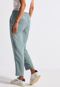 Hellblaue, leichte Hose mit elastischem Bund, Seiten Taschen und geradem Schnitt, ergänzt durch kontrastierende weiße Akzente.