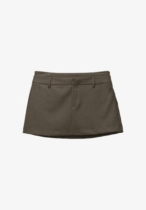 Brauner Rock mit maßgeschneidertem Design, ausgestattet mit Gürtelschlaufen, zwei Fronttaschen und einem strukturierten Stoff. Der Saum ist leicht rund.