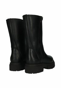 Botas de tobillo de cuero negro con textura suave, punta redondeada y cremallera lateral. Suela de goma gruesa con detalles de relieve.