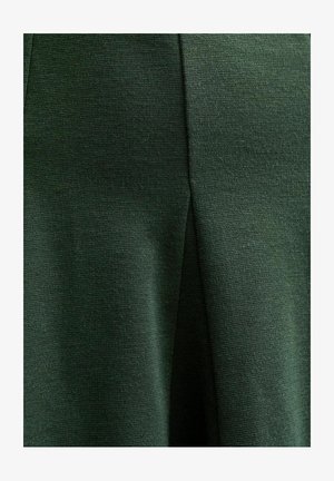 Grüner Stoff mit einer strukturierten Webart und einem subtilen Glanz. Das Material fällt glatt und zeigt ein sauberes, strukturiertes Design.